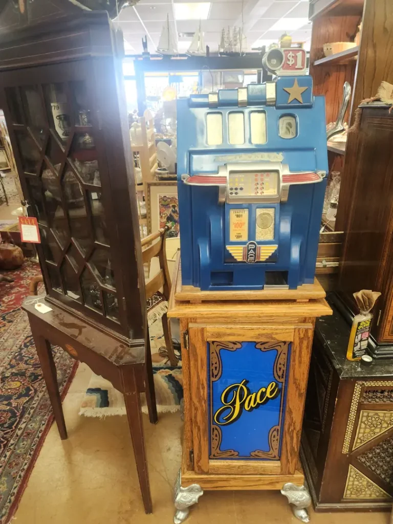 A vintage blue slot machine with a wooden base labeled 