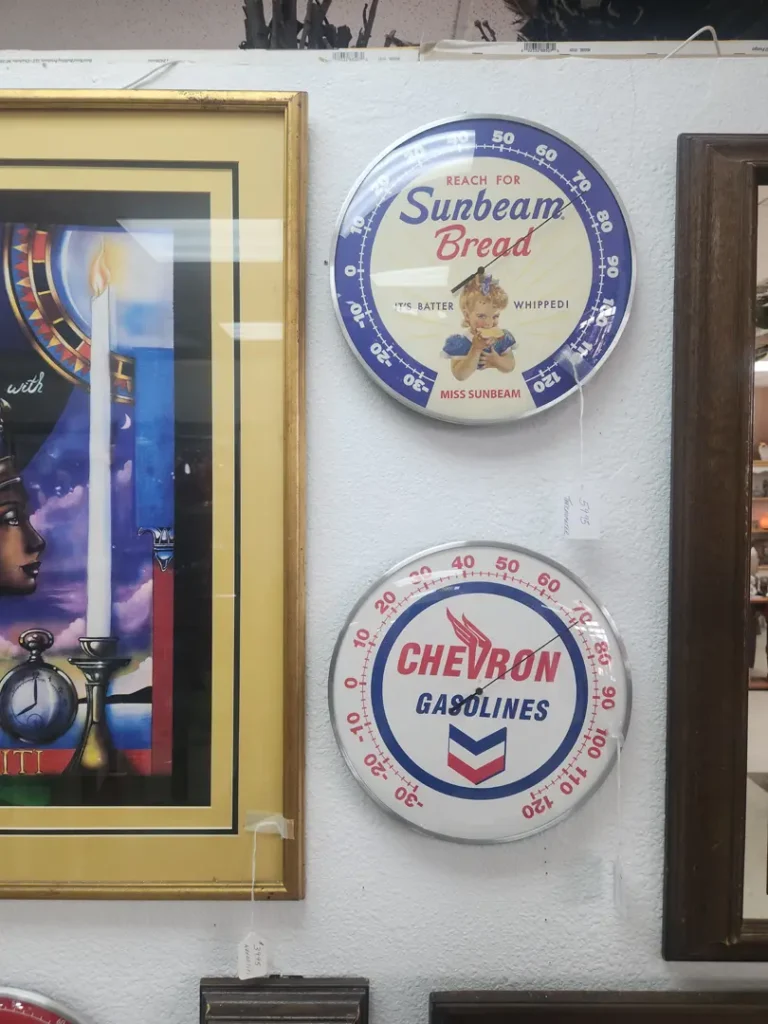 Two vintage round thermometers on wall