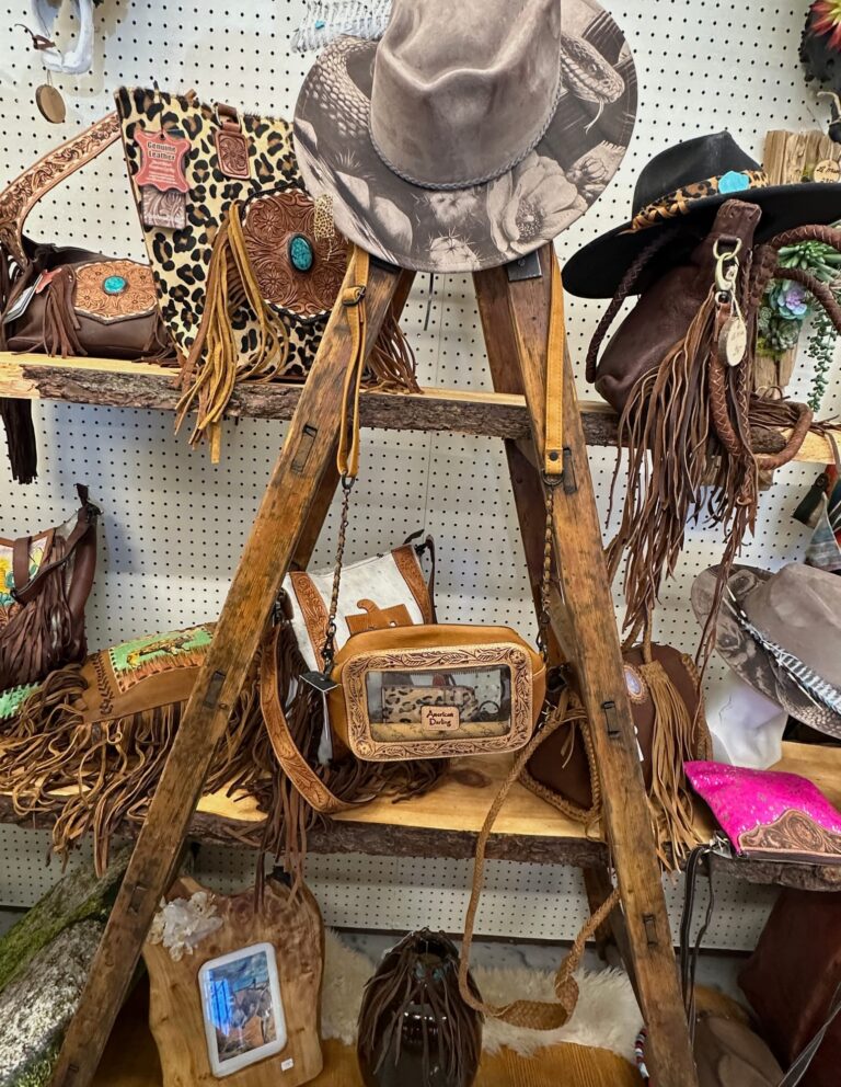 Western hats and fringed leather bags on rustic shelves